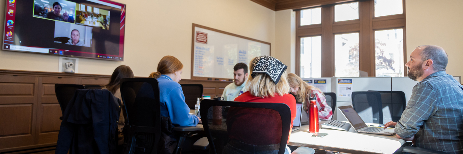 Students sit around a Zoom meeting in the Arnolt Center.