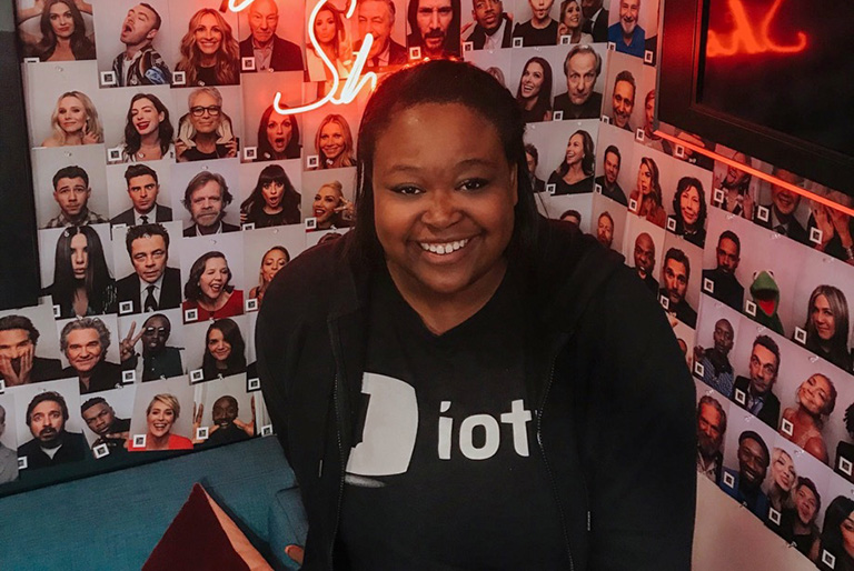 A student smiles in front of The Late Night Show backdrop in Los Angeles.