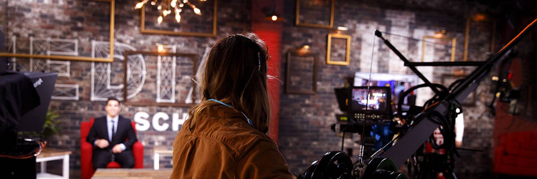 A student operates a piece of equipment on a production set.